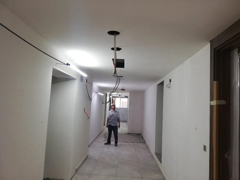 Khu vực hành lang đã được sơn và đang lắp đặt hệ thống điện.